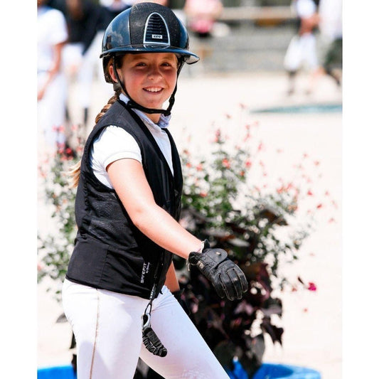 Smiling young rider wearing the SAFEFIT Junior Airbag Vest over a white show shirt, showing the low-profile fit.